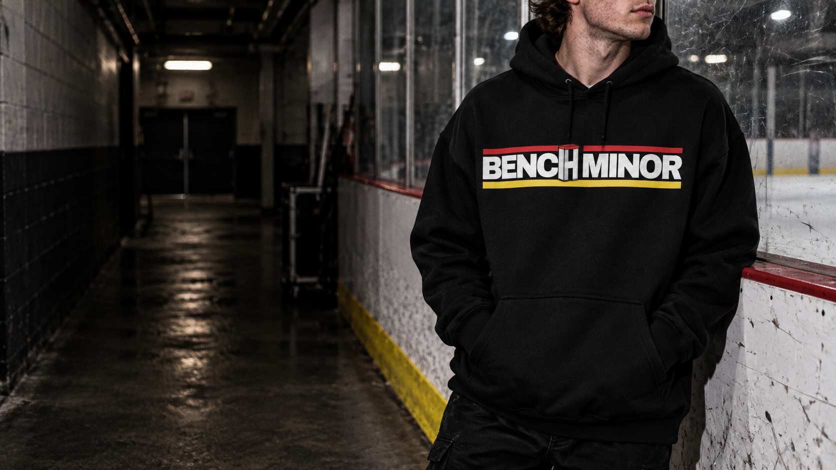 Bench Minor hoodie worn beside the boards in a hockey rink tunnel